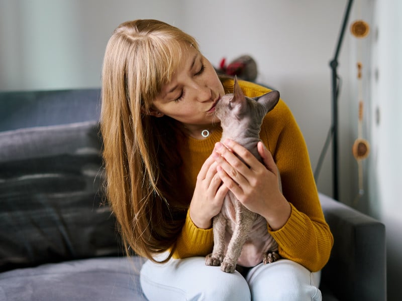 A woman kissing a domesticated cat