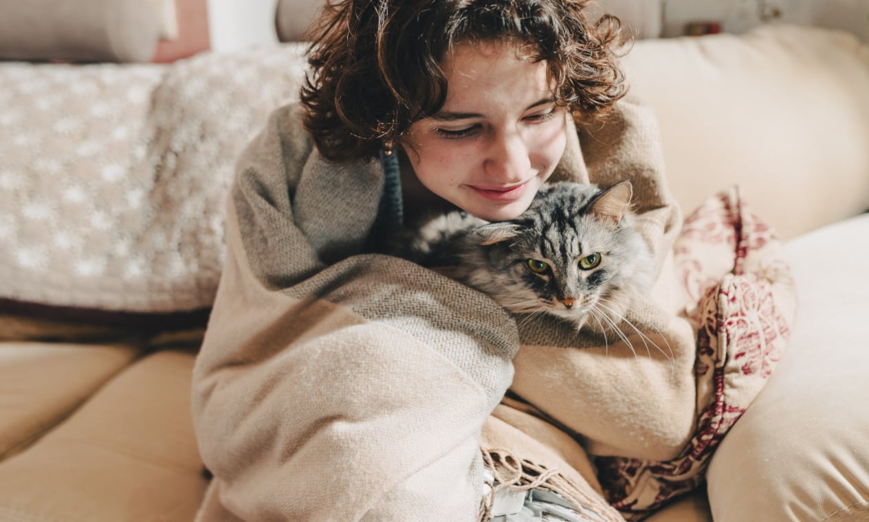 A woman snuggling with a cat